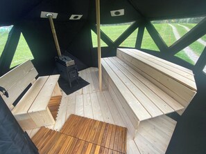 A wooden deck with benches and a fireplace. - Chalet Legi Ferienhaus, Dusche oder Bad, WC, 4 oder mehr Schlafräume Chalet Legi by Interhome (Adelboden)