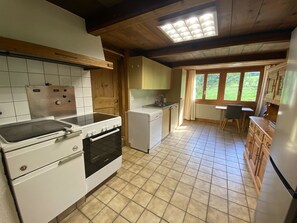 A compact kitchen with a stove, oven, and a small refrigerator. - Chalet Legi Ferienhaus, Dusche oder Bad, WC, 4 oder mehr Schlafräume Chalet Legi by Interhome (Adelboden)
