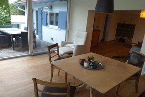 A dining area with a table, chairs, and a fireplace. - Holiday home with 4 bedrooms (Altusried)