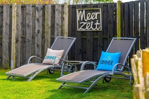 Two lounge chairs with cushions, a wooden fence, and a sign that reads 'Meer Zeit'. - Meerhuus Carolinensiel House 1 (Carolinensiel)