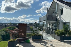 Ein Wohngebäude mit Balkon, Treppe und Blick auf die Umgebung.