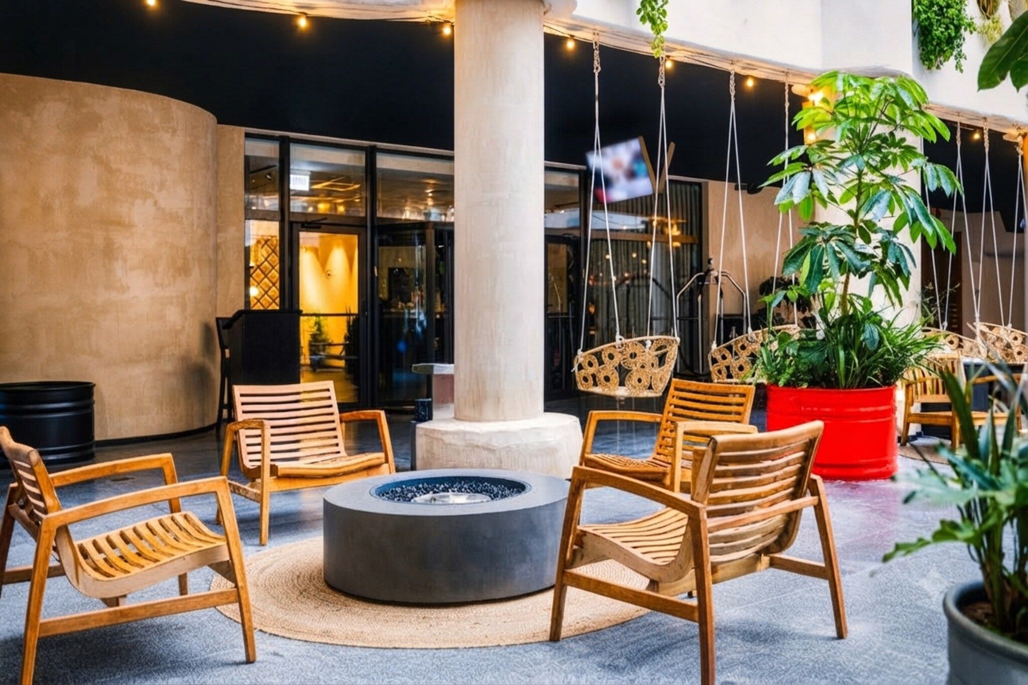 Un espace extérieur moderne aménagé avec des chaises en bois et un foyer central.