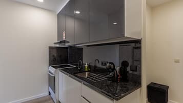 A modern kitchen with a built-in oven, a sink, and a coffee machine.
