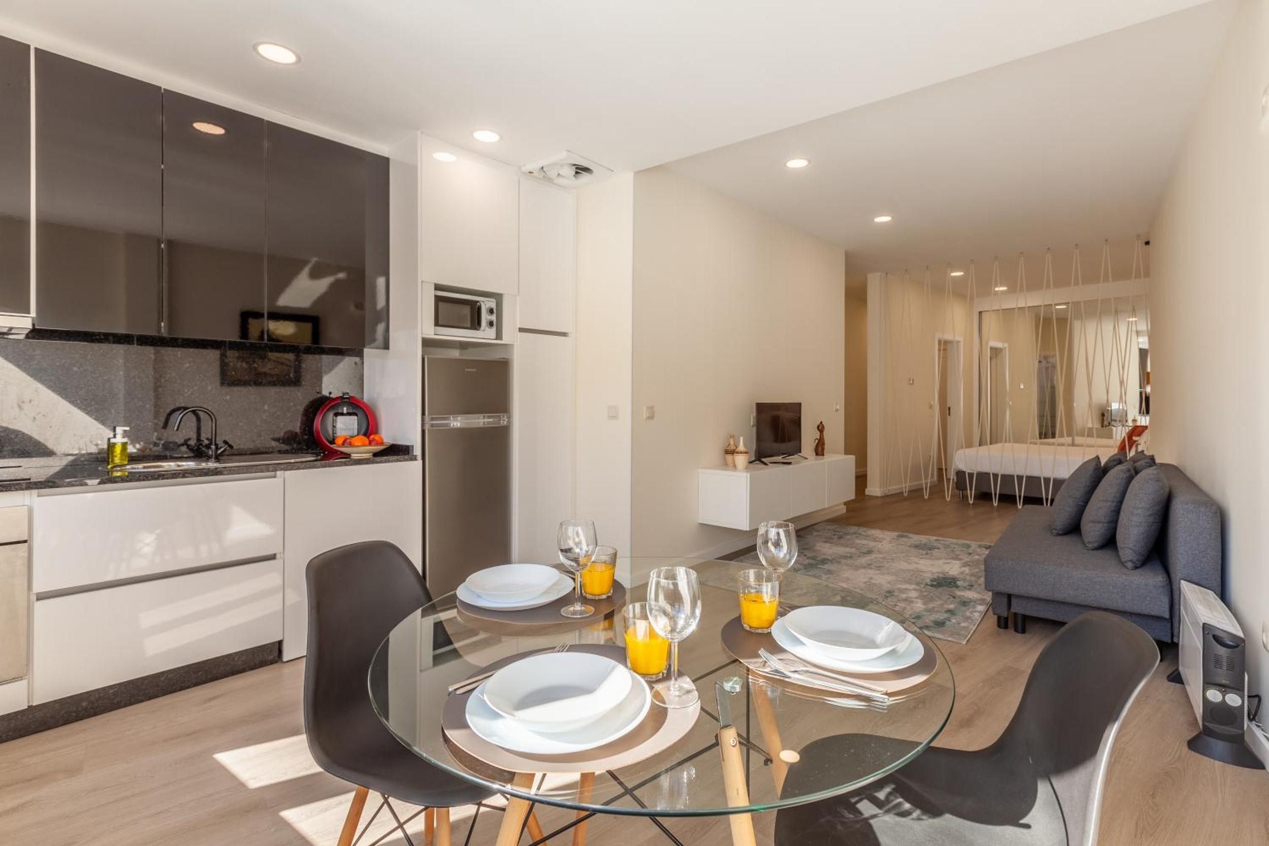 Una cucina moderna con zona pranzo, divano e TV.