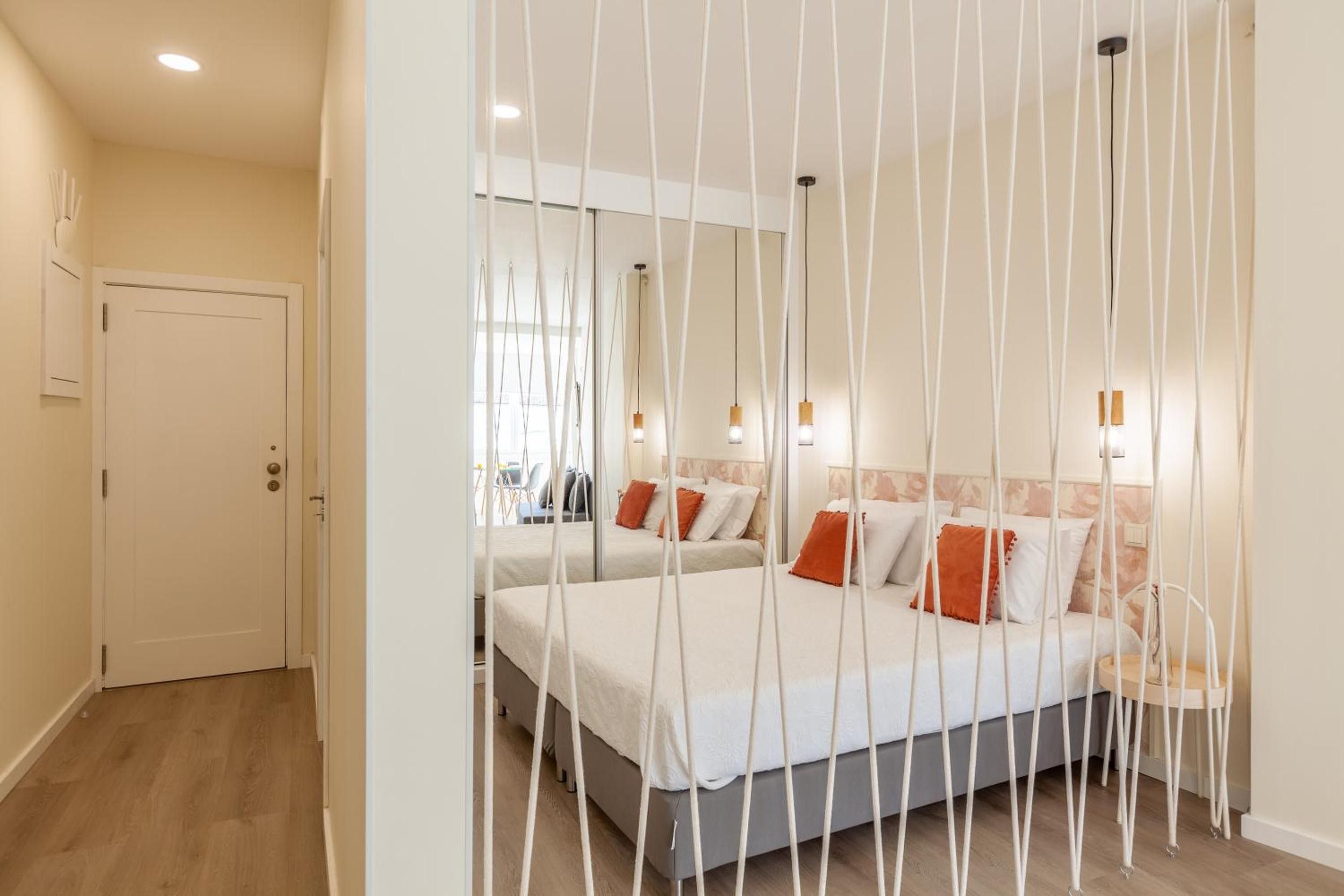 Una habitación de hotel con dos camas, una puerta y vistas al exterior.