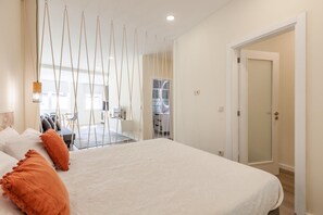 Habitación de hotel con una cama, un escritorio y vistas a la cocina y el comedor.