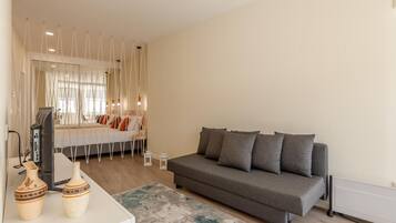 Una sala moderna con un sofá gris, una mesita blanca y un tapete decorativo.
