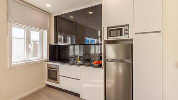 A modern kitchen with a built-in oven, microwave, and refrigerator.