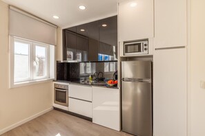 Eine moderne Küche mit Einbauofen, Mikrowelle und Kühlschrank.