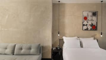 Quarto com cama, mesa de cabeceira e uma obra de arte na parede.