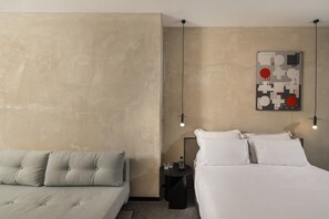 Un dormitorio con cama, mesita de noche y una obra de arte colgada en la pared.