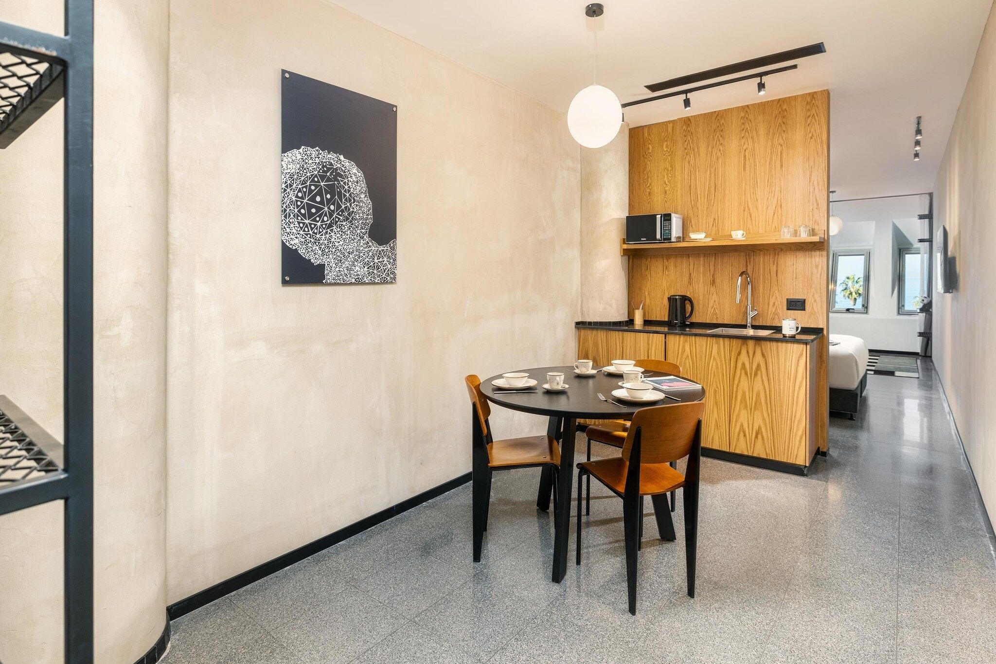 A modern interior with a dining area, kitchen, and a view of the sea.