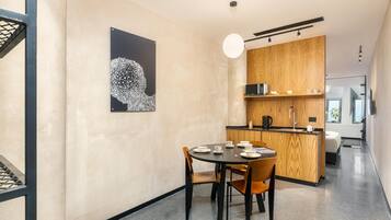 A modern interior with a dining area, kitchen, and a view of the sea.