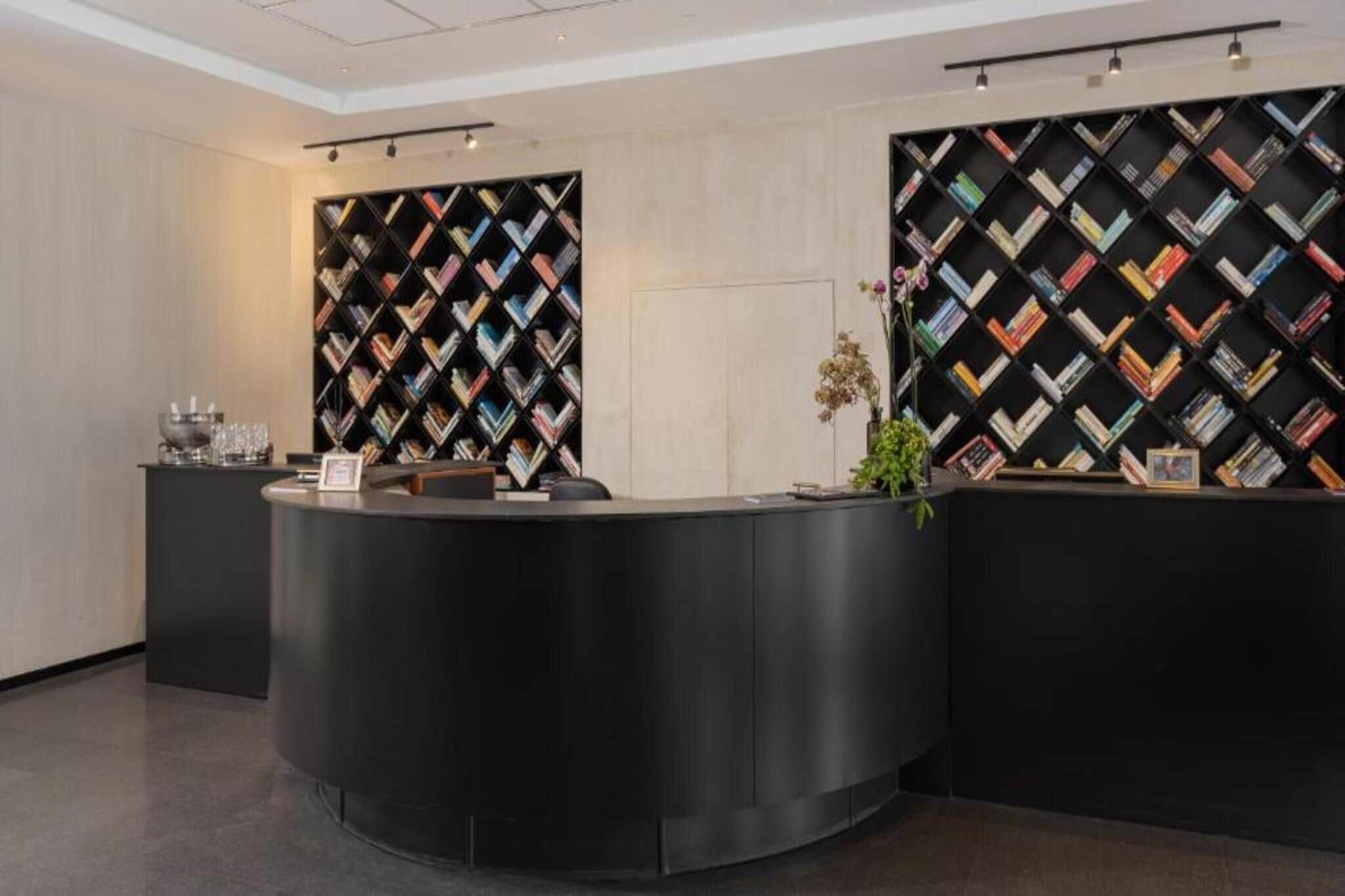 Una recepción de diseño moderno, flanqueada por dos grandes estanterías negras con motivo de diamantes.