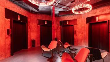 A conference room with red walls, a round table, and four red chairs.