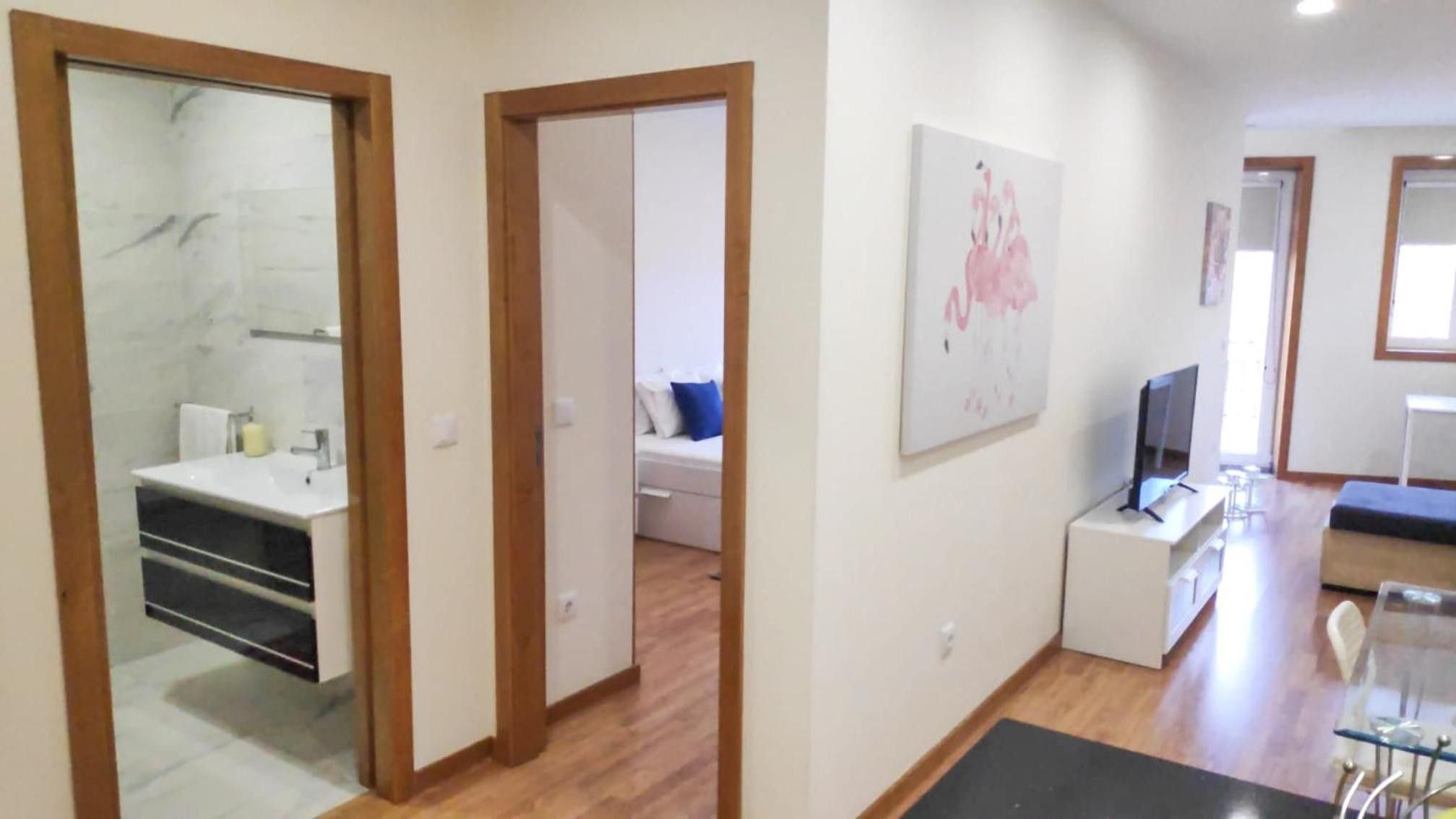 A modern apartment with a bathroom, a living area, and a bedroom.