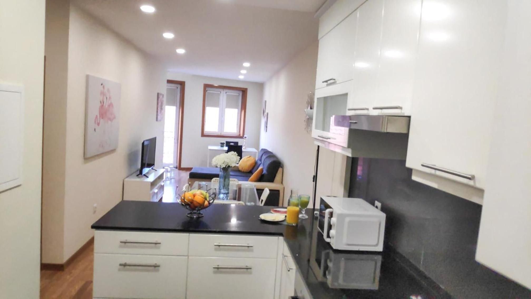 A compact kitchen with a dining area, a microwave, and a TV.