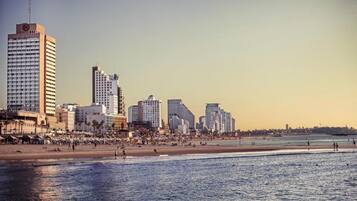 A coastal cityscape with high-rise buildings and a beach.