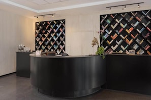 Una recepción de diseño moderno, flanqueada por dos grandes estanterías negras con motivo de diamantes.