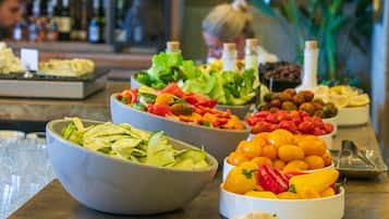 Buffet com diversas opções de comida, incluindo saladas, frutas e legumes.