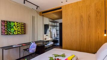 Une chambre d’hôtel moderne équipée d’un lit, d’un bureau, d’un miroir et d’un mur recouvert de panneaux en bois.