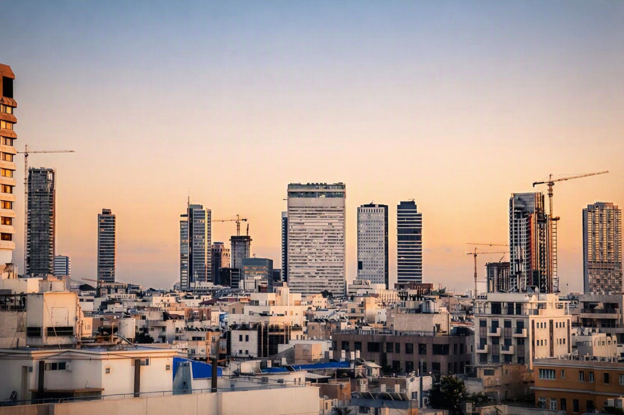 Linha do horizonte urbana com vários edifícios altos, alguns em construção, e uma combinação de edifícios residenciais e comerciais.
