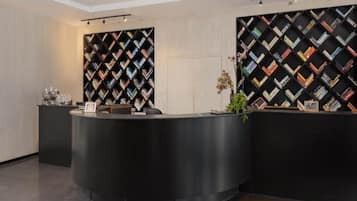 Una recepción de diseño moderno, flanqueada por dos grandes estanterías negras con motivo de diamantes.