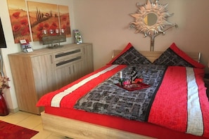 A bedroom with a bed, a wooden dresser, and a mirror on the wall. - Apartment in Lohmar with swimming pool (Lohmar)