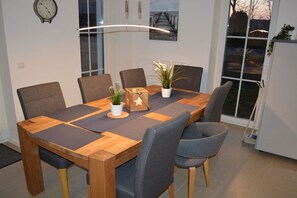 Ein Essbereich mit einem Holztisch, sechs Stühlen und einem Blumentopf.