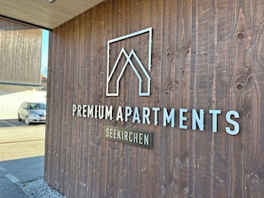 A wooden wall with a logo and text indicating "PREMIUM APARTMENTS SEEKIRCHEN". - Premium Apartment SIX, Stylish Apartment with a Garden and Terrace (Seekirchen am Wallersee)