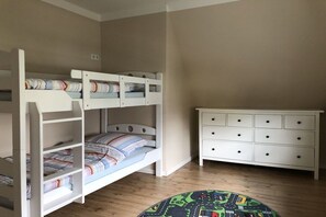 A room with bunk beds, a dresser, and a round rug. - Apartment in Cuxhaven with swimming pool (Cuxhaven)