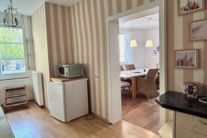Eine kleine Küche mit einem Kühlschrank, einer Mikrowelle und einem Tisch.