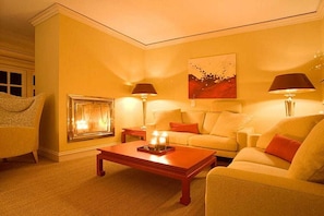 Ein gemütliches Wohnzimmer mit einer Couch, einem Couchtisch mit Kerzen und zwei Lampen.