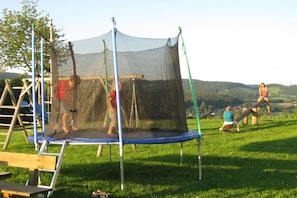 Ein Trampolin mit Sicherheitsnetz im Freien.