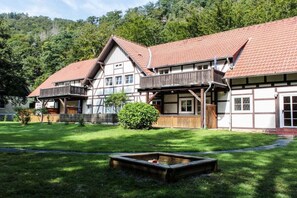 A traditional chalet with a sloped roof, wooden balconies, and a well-maintained lawn. - in the holiday home Nexö - 2 bedrooms (Ilsenburg)