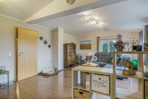 Un salon spacieux avec un canapé, un meuble en bois et un élément décoratif mural.