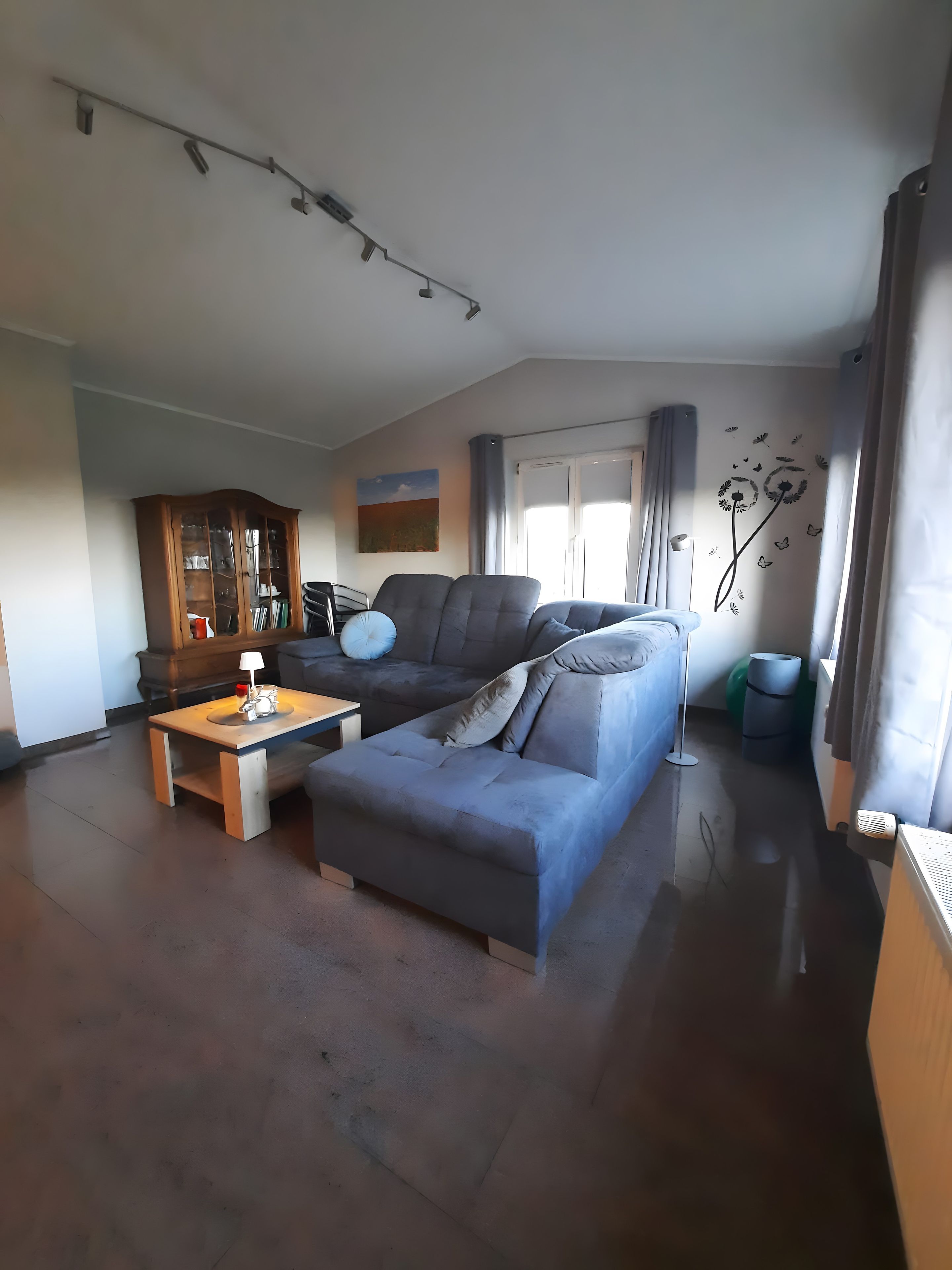 Una sala de estar con un sofá, una mesa de centro y un aparador.