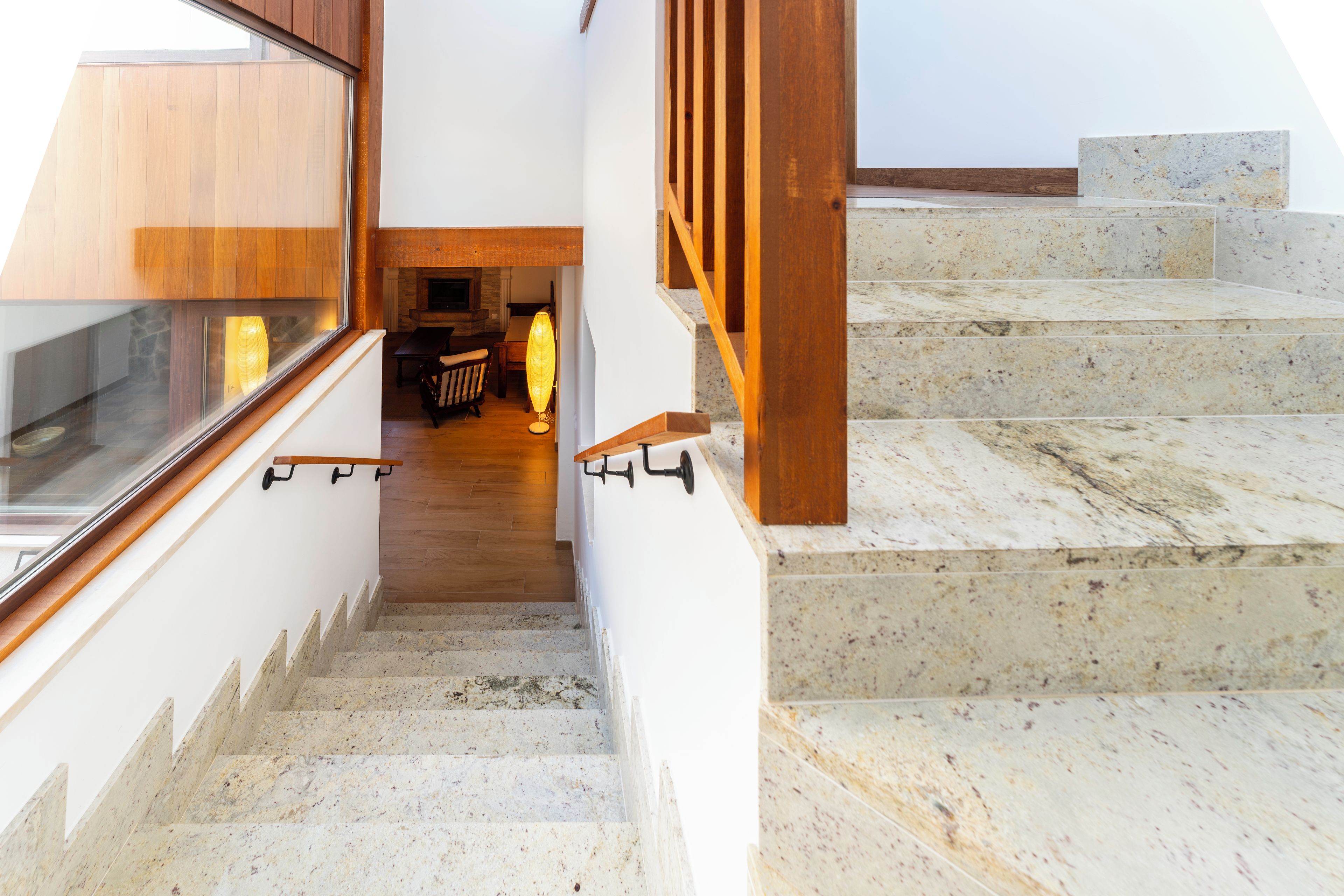 Una escalera con barandillas de madera y vistas a una habitación con chimenea.