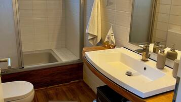 Ein Badezimmer mit Badewanne, Toilette, Waschbecken und Dusche.