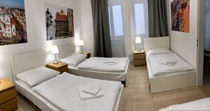 A hotel room with two single beds, a nightstand with a lamp, and a large window with curtains. - Spacious 1-bedroom apartment in Prague Old Town (Prague)