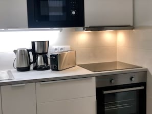Una cocina moderna con microondas, cafetera, tostadora y horno.