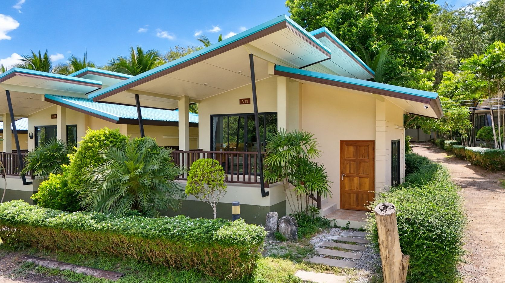 A hotel with a covered outdoor area, a wooden door, and a paved walkway.