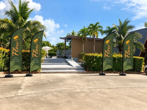 A resort entrance with palm trees and a clear sky.