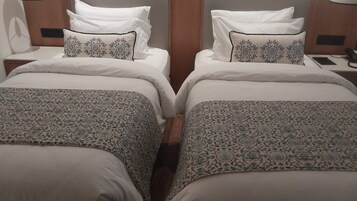 Una cama doble con una colcha estampada y dos almohadas con diseño floral.