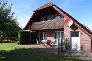 A two-story house with a brick exterior, a sloped roof, and a satellite dish. - Holiday home in Hooksiel with swimming pool (Hooksiel)
