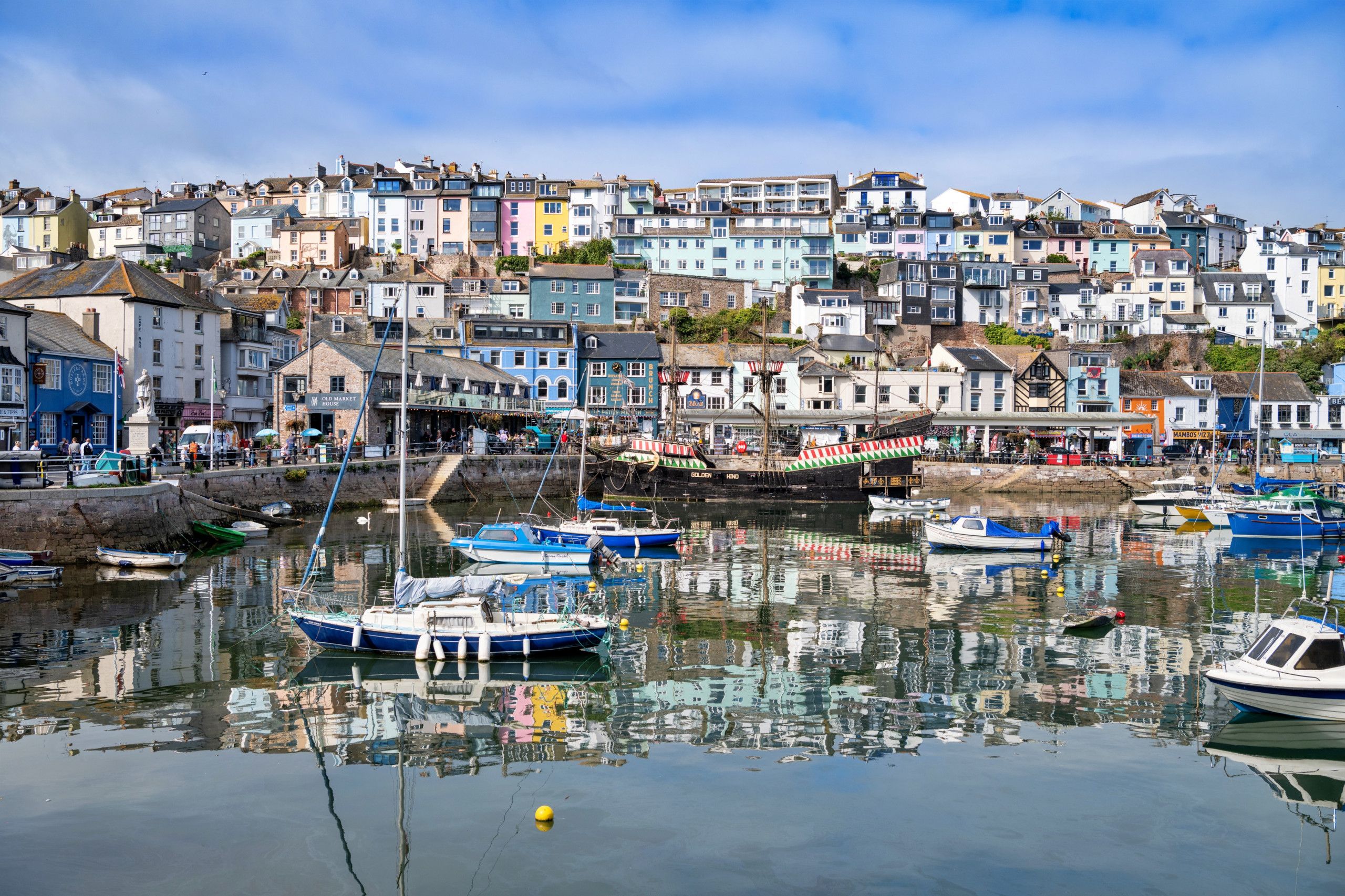 A harbor with boats, a bridge, and colorful buildings.