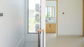 A modern interior with a large window, a staircase, and a minimalist bathroom.