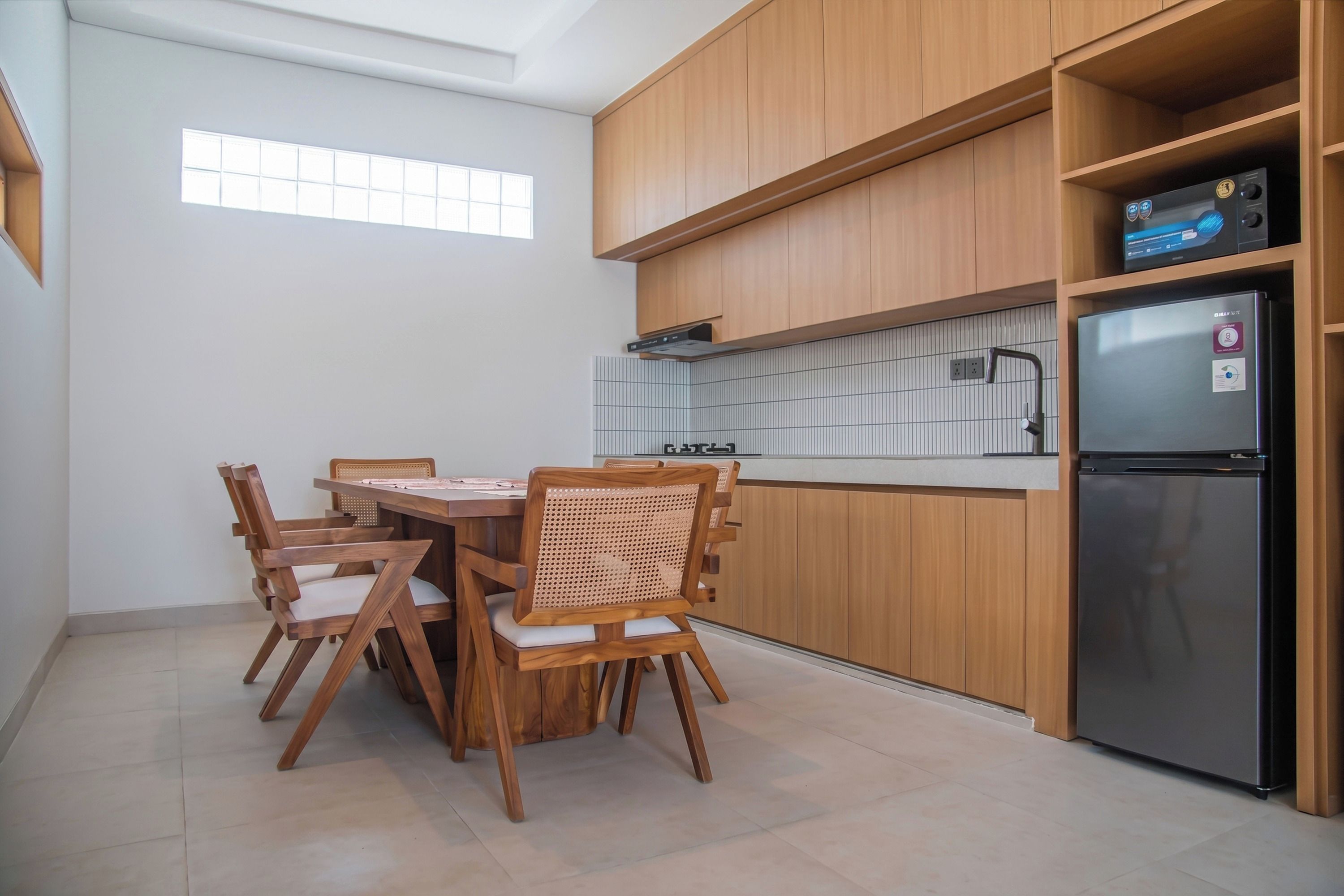 Una cocina moderna con armarios de madera, estufa integrada y refrigerador.