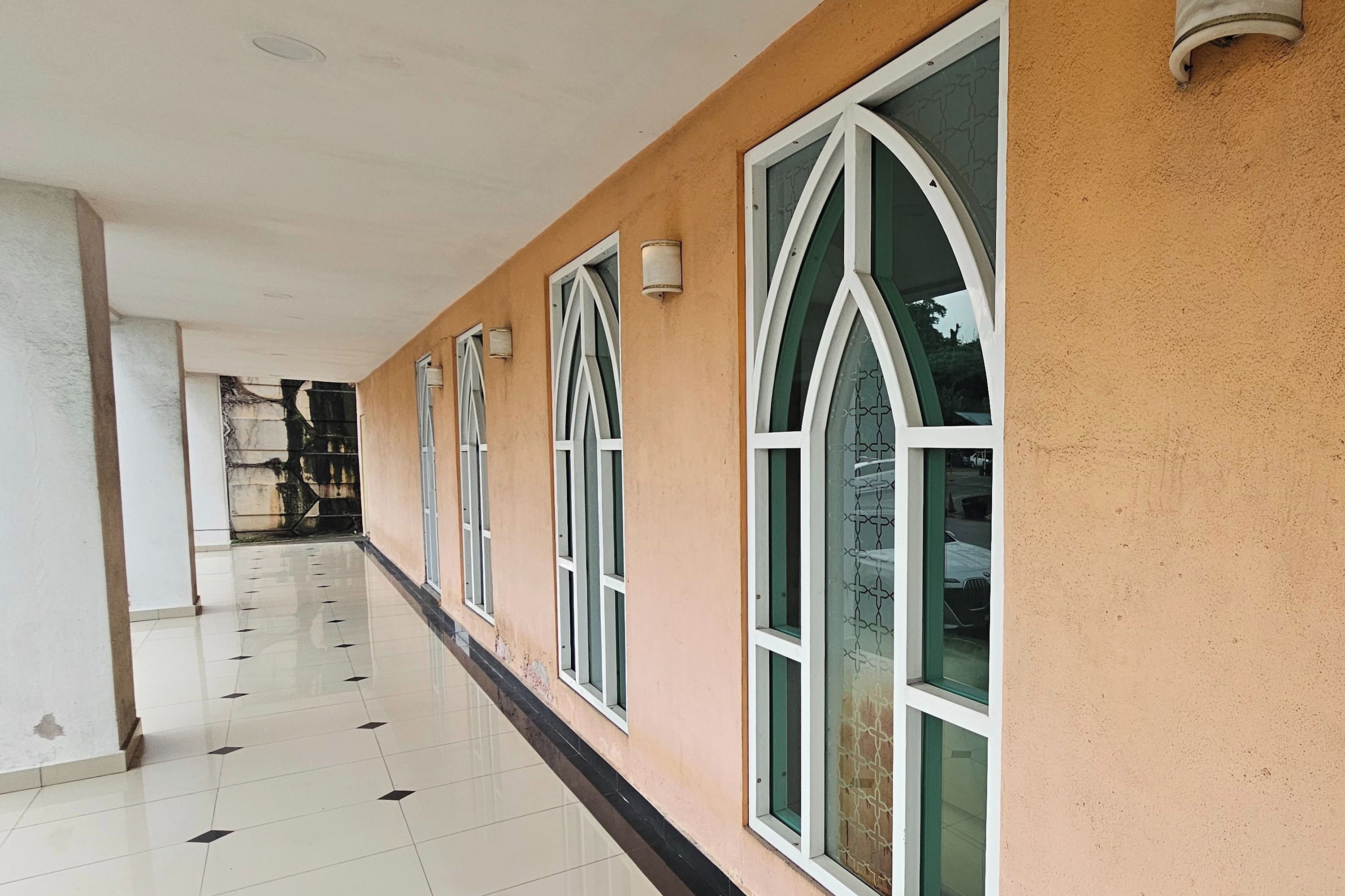 A corridor with large windows and a tiled floor.