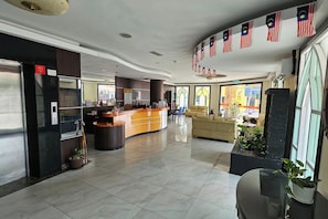 A hotel lobby with a reception desk, a sofa, and a coffee table. - Hotel Sahara Rawang (Rawang)